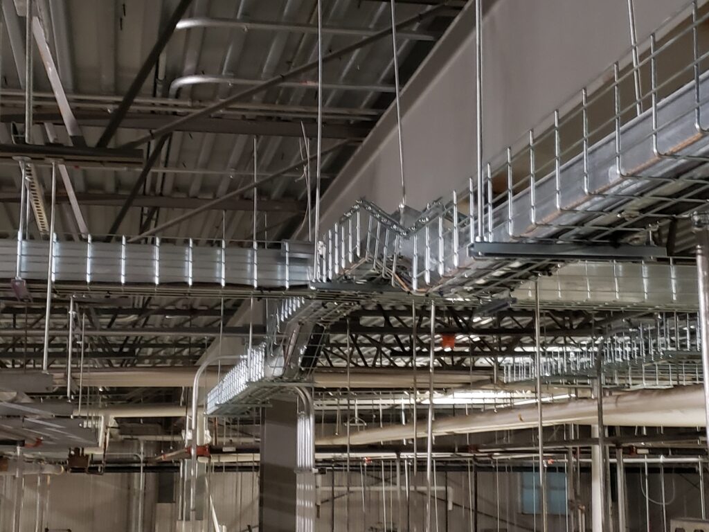 Overhead metallic structure showcasing a complex array of pipes, beams, and walkways.

