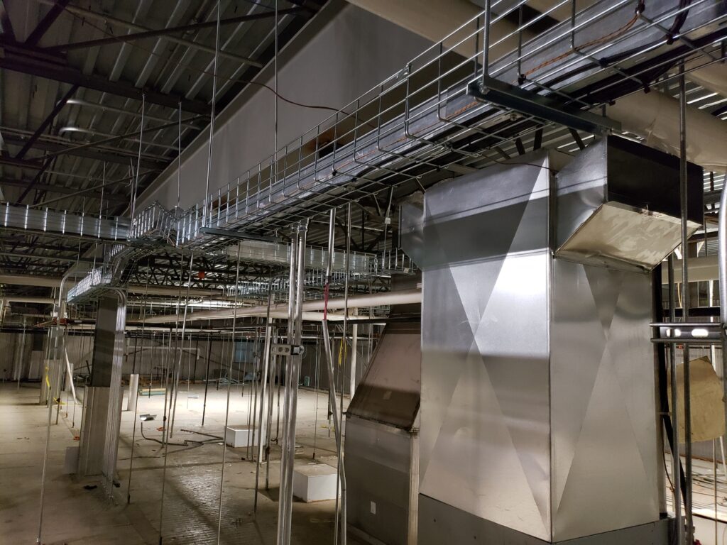 Detailed view of suspended cable trays and conduits, supported by a metallic framework.