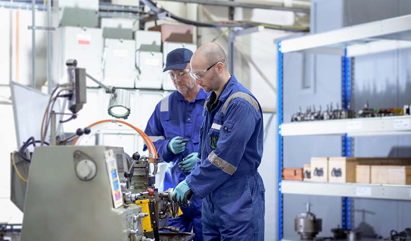 PEC employees performing industrial equipment maintenance 