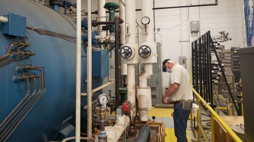 PEC employee inspecting industrial equipment